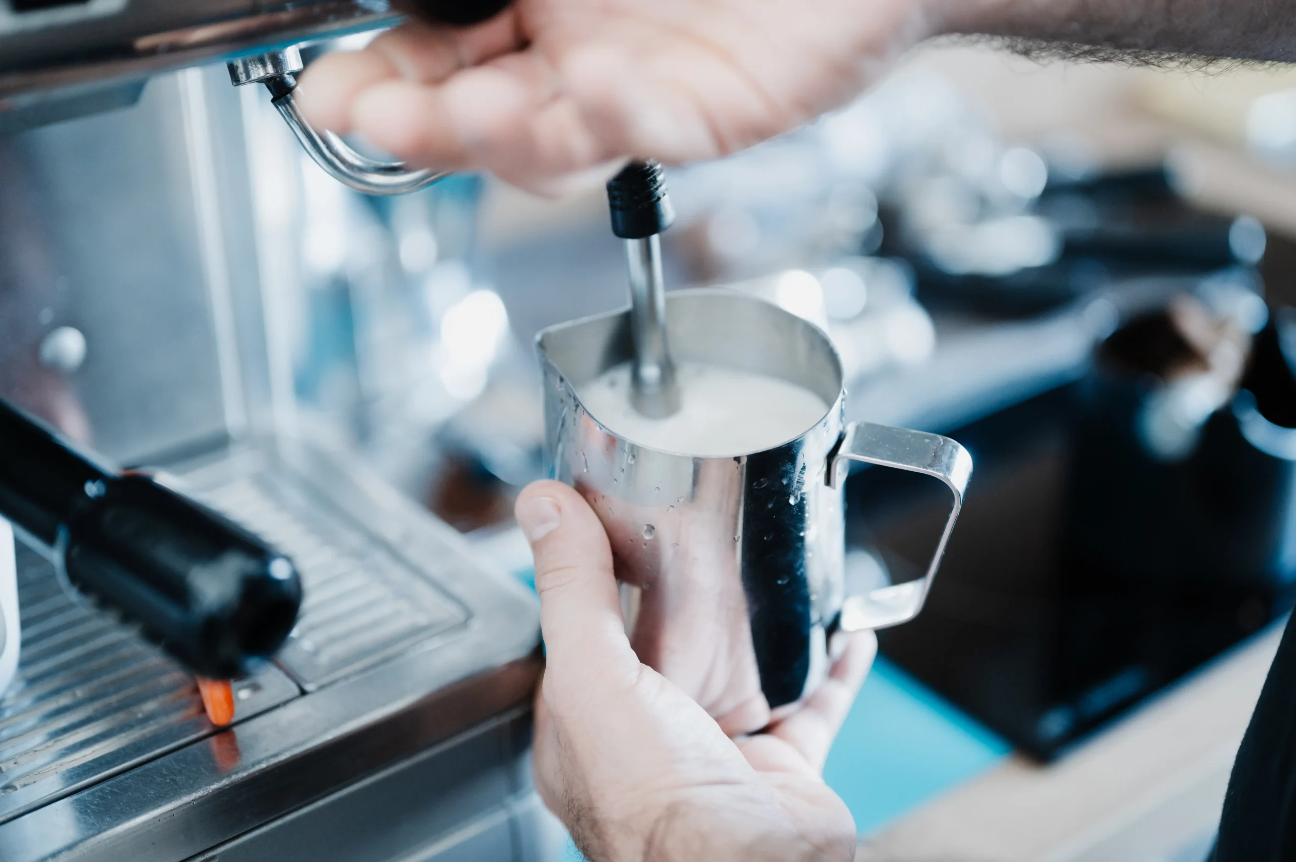 Mitarbeiter schäumt Milch an unserer Bistro-Kaffeemaschine auf