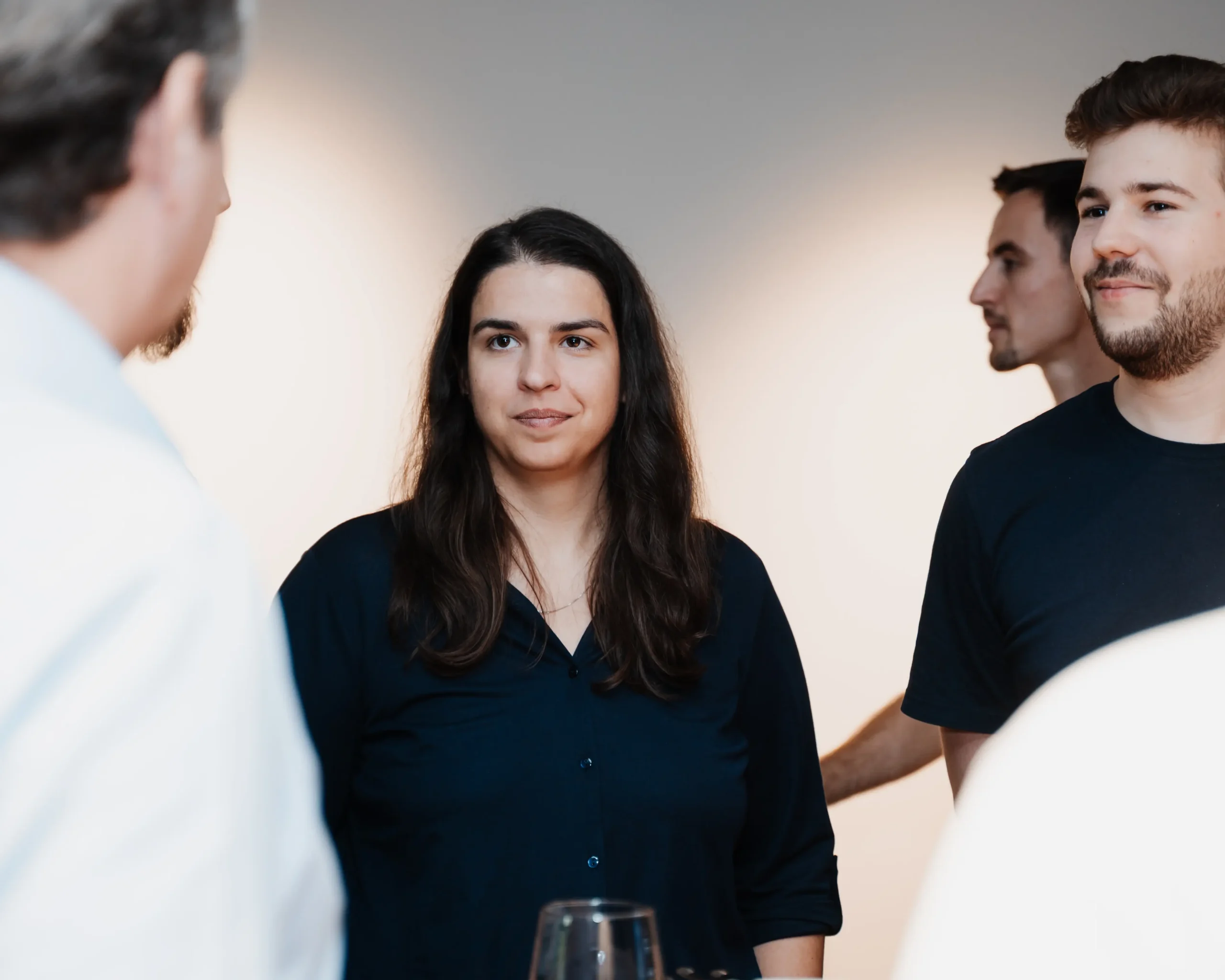 Mitarbeiterinnen und Mitarbeiter stehen in einem Kreis und unterhalten sich freundlich